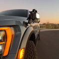 Load image into Gallery viewer, A portable scene light mounted on the side of a vehicle, showcasing its robust design and preparation for illumination in dark environments.
