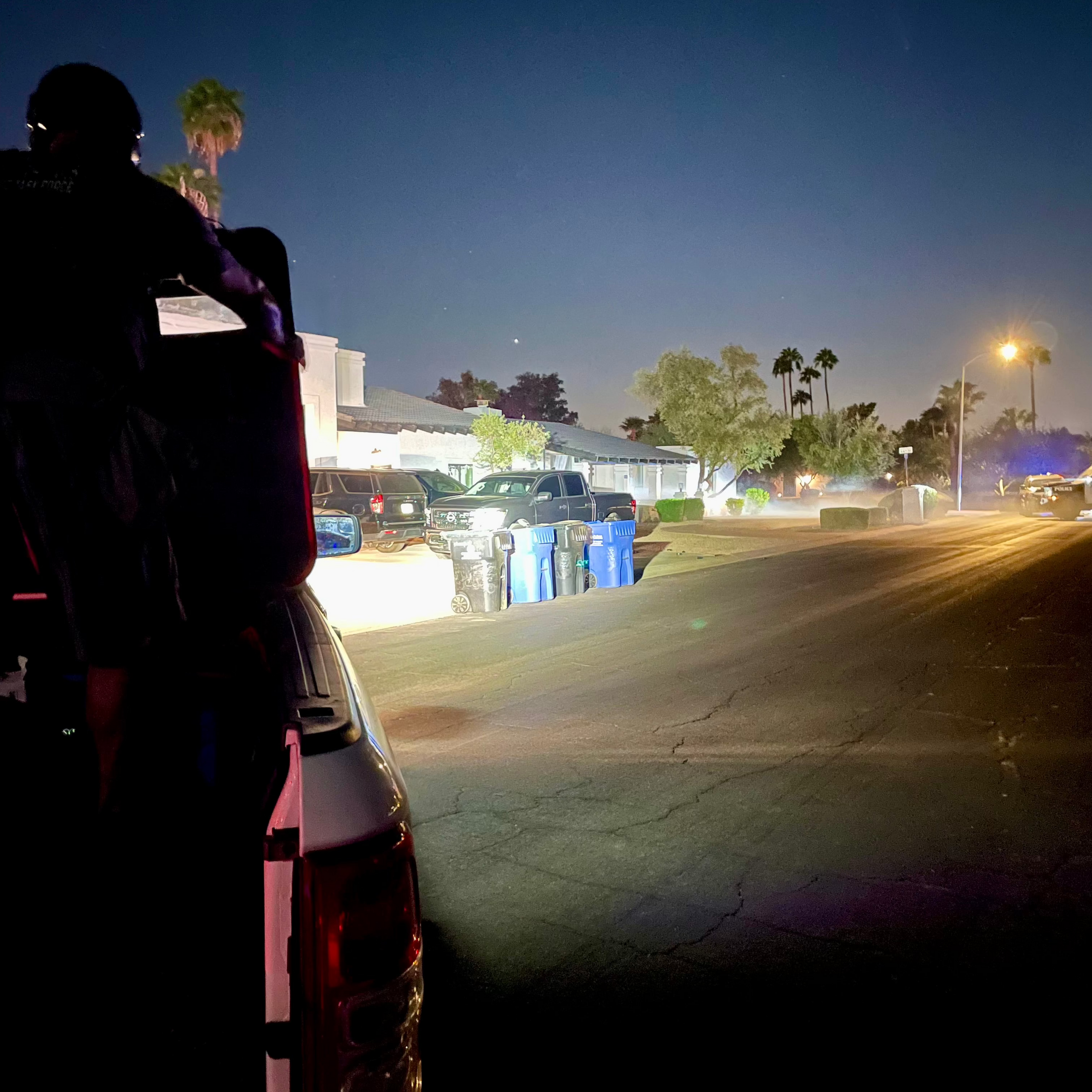 Police Officer standing on truck utilizing a Vector ballistic shield light to illuminate a dark scene and night sky.